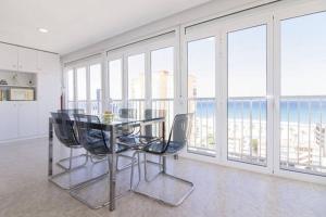 comedor con mesa, sillas y ventanas en Apartamento Beach & Chic San Juan, en Alicante