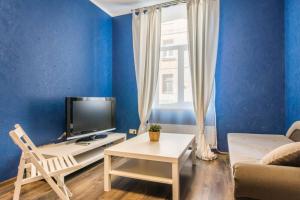 a blue living room with a tv and a couch at Self check in/out. 5 can stay. Free parking. Close to the city center. in Rīga