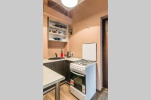 a small kitchen with a stove and a refrigerator at Self check in/out. 5 can stay. Free parking. Close to the city center. in Rīga