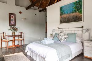 a bedroom with a bed and a table and a chair at Oude Compagnies Post in Tulbagh