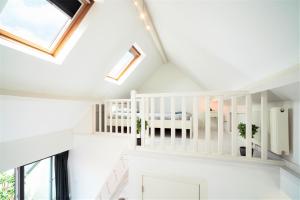 una camera con pareti bianche e soffitti con lucernari di Beautiful Cozy Apartments in the Heart of Antwerp ad Anversa