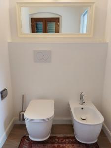 La salle de bains est pourvue de toilettes blanches et d'un lavabo. dans l'établissement Castle Rooms, à Prato