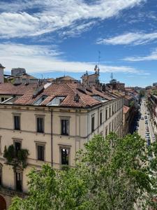 a large white building with red tile roofs at Sant'Ambrogio with charme in Milan