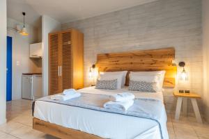a bedroom with a large bed with towels on it at ARMONIA 1 & 2 in Myrina +33 photos