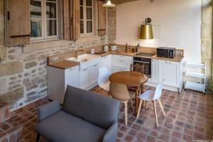 cocina con mesa, sillas y fregadero en HANAËL, Gîte en maison d'hôtes, en Aubais