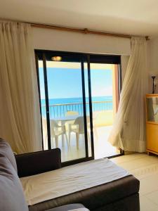 a bedroom with a view of the ocean from a balcony at Apartamento Playa Peñíscola in Peniscola