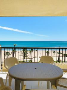 una mesa y sillas en un balcón con vistas a la playa en Apartamento Playa Peñíscola, en Peñíscola