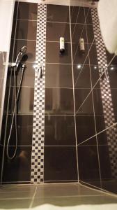 a bathroom with a shower with black tile at Amical Hotel Hagen in Hagen