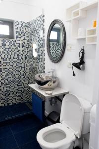 La salle de bains est pourvue de toilettes, d'un lavabo et d'un miroir. dans l'établissement Solemar Boutique, à Eforie Sud