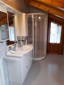 a white bathroom with a shower and a sink at Casa Al Noce Mastellina Apt. Solandra in Commezzadura