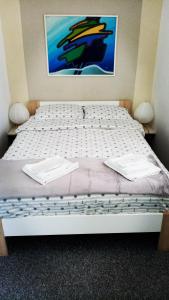 Art Apartman في بليتفيتْشكا ييزيرا: سرير مع وسادتين بيض عليه في غرفة
