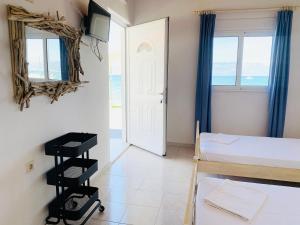 a room with two beds and a door with a window at Seaside Bungalows Petalidi in Petalidi