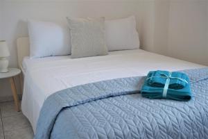 a bed with a blue bag sitting on top of it at Katerinas House in Nikiti