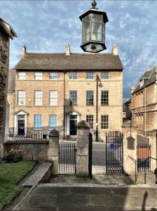 un antiguo edificio de ladrillo con una torre luminosa en la parte superior en St Martins Apartment Stamford en Stamford