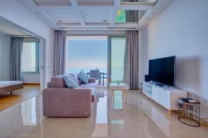 uma sala de estar com um sofá e uma televisão de ecrã plano em Luxurious Apt with Ocean Views and Pool in Tigne Point em Sliema