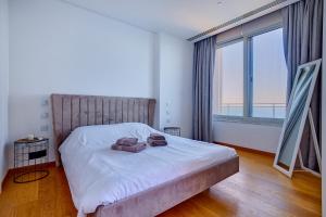 斯利马Luxurious Apt with Ocean Views and Pool in Tigne Point的一间带床和大窗户的卧室 更多33张照片