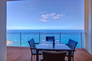 斯利马Luxurious Apt with Ocean Views and Pool in Tigne Point的阳台上的一张桌子，可以欣赏海景