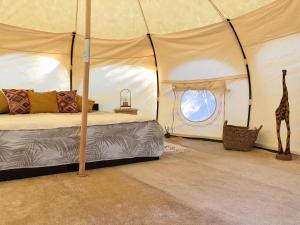 a bedroom with a bed and a giraffe in a tent at VinSan Glamping & Wellness Centre in Eleoúsa