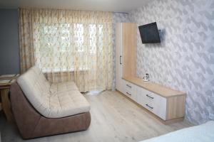 Путивль Квартира студия في Putyvlʼ: غرفة نوم مع أريكة وتلفزيون في غرفة