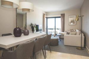 una cucina e un soggiorno con tavolo e sedie di Exclusivo apartamento en Los Flamingos Golf a Estepona