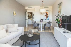 un soggiorno con divano bianco e tavolo di Exclusivo apartamento en Los Flamingos Golf a Estepona