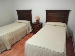duas camas sentadas uma ao lado da outra num quarto em CASTILLO DE LUNA em Alburquerque