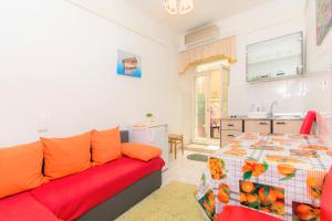 a living room with a red couch and a kitchen at Dubrovnik center apartment in Dubrovnik
