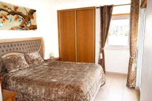 a bedroom with a bed and a window at Clube Meia Praia in Lagos