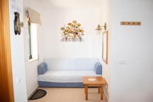 a room with a blue couch and a table at Clube Meia Praia in Lagos