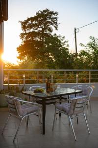 a table and chairs on a patio with the sunset at Anastasia's House 2 in Plátanos