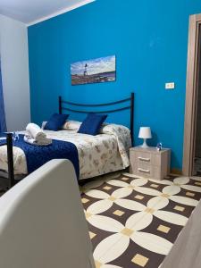 a blue bedroom with a bed and a blue wall at Villa Del Mare in Campomarino