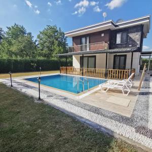 a villa with a swimming pool and a house at Meral Resort in Sapanca