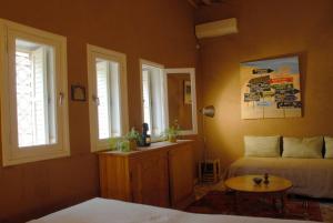 a bedroom with a bed and a table and windows at Villa Zagora Ma Villa au Sahara in Zagora