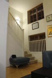 ein Wohnzimmer mit einer Treppe und einem Stuhl in der Unterkunft Central 2-Bed, 2-Bath Sanctuary near Holborn Station, Covent Garden & West End in London