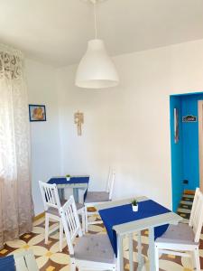 a dining room with white chairs and a table at Villa Del Mare in Campomarino