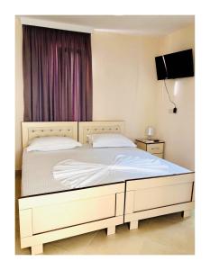 sypialnia z dużym łóżkiem z białą pościelą w obiekcie R HOTEL w mieście Çorovodë