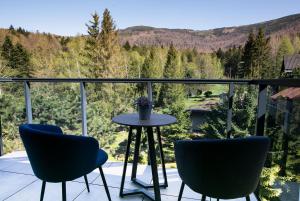 eine Terrasse mit 2 Stühlen und einem Tisch auf dem Balkon in der Unterkunft Śnieżynka in Szczyrk