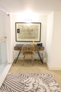 a desk with a chair and a picture on the wall at Central 2-Bed, 2-Bath Sanctuary near Holborn Station, Covent Garden & West End in London