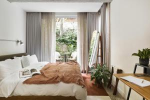 um quarto com uma cama e uma grande janela em The Saul Hotel em Tel Aviv
