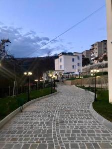 brukowana ulica w mieście nocą w obiekcie R HOTEL w mieście Çorovodë