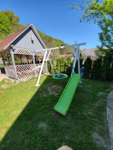 a playground with a green slide in a yard at Casa Marian in Sighişoara