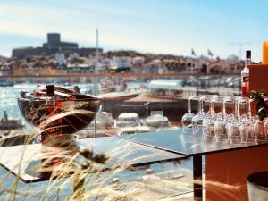 a glass table with wine glasses on a balcony at Marstrands Havshotell in Marstrand