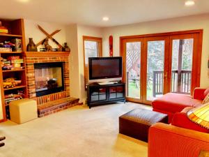 a living room with a television and a fireplace at C3 Crawford Ridge Townhome with Mt Washington views - just a short walk from ski lodge and slopes in Carroll
