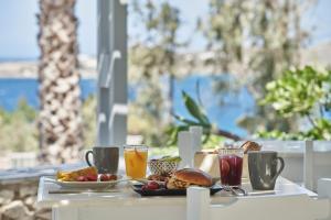 a table with a plate of food and drinks at High Mill Paros Hotel in Parikia
