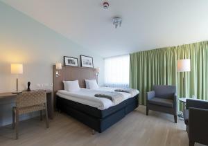 1 dormitorio con cama, escritorio y silla en Marstrands Havshotell, en Marstrand