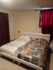 een slaapkamer met 2 bedden en een rood gordijn bij Michela in Monteforte dʼAlpone