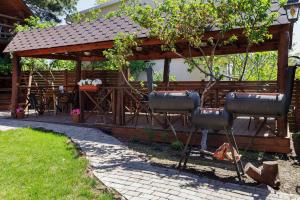 a pergola with chairs and a table in a yard at Sosnovy Dvor Guest House in Sevastopol
