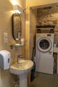 a bathroom with a sink and a washing machine at Agalide in Kissamos