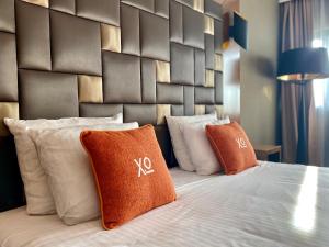 a bed with pillows and pillows on top of it at XO Hotels Park West in Amsterdam