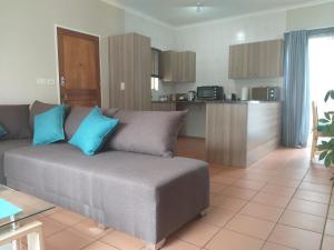 a living room with a couch and a kitchen at Burban Bliss in Johannesburg